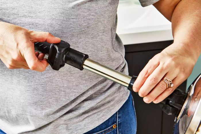 A person adjusts the handle of the Bissell Commercial CycloMop Spin Mop.