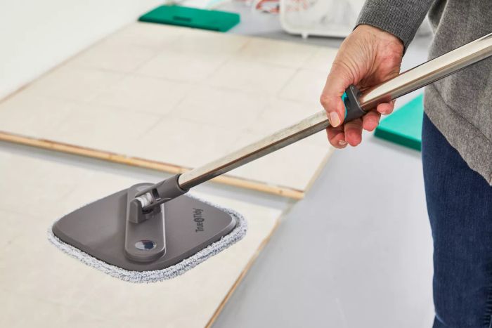 Person adjusting the handle on the True & Tidy TrueClean Spin Mop and Bucket System