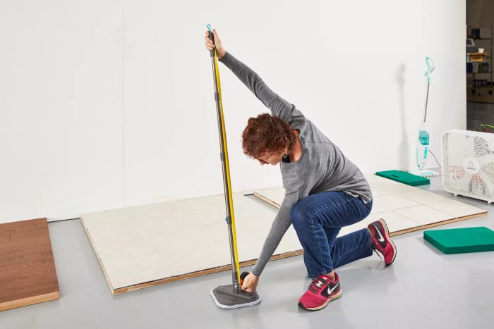 Person using a measuring tape to check the length of the handle on the True & Tidy TrueClean Spin Mop and Bucket System