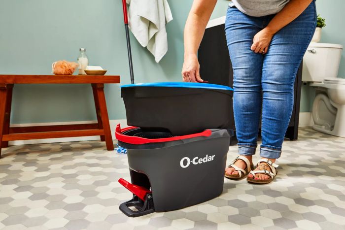A person lifts the O-Cedar EasyWring RinseClean Spin Mop & Bucket System out of the bucket