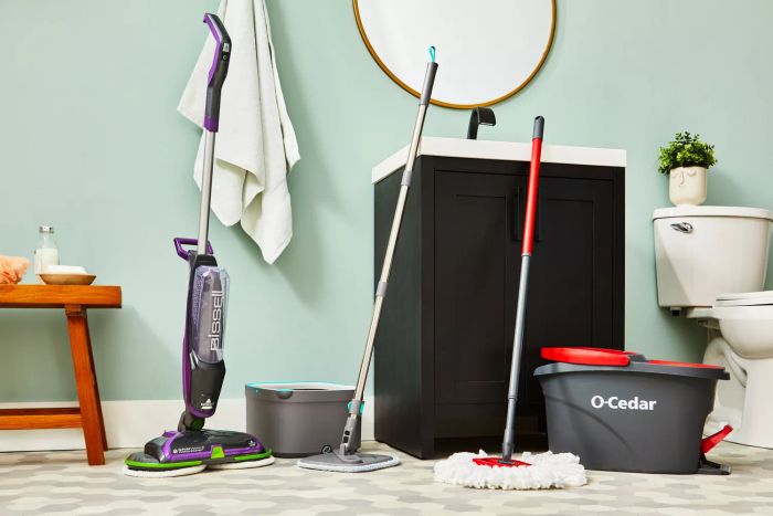 A variety of spin mops placed in a bathroom setting
