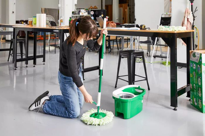 A person adjusts the Libman Tornado Spin Mop and Bucket Floor Cleaning System