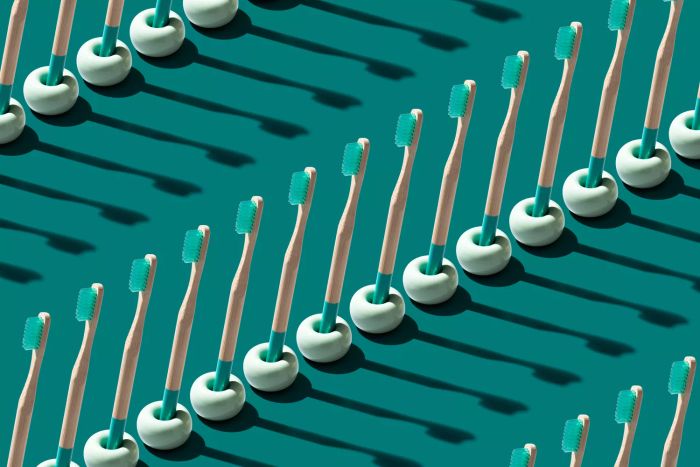 Rows of Green Biodegradable Bamboo Toothbrushes on a Green Background.