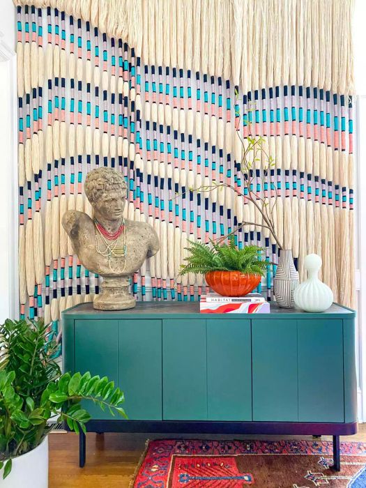 Vibrant Entryway Decor Idea, featuring a teal console storage cabinet with a bust on top