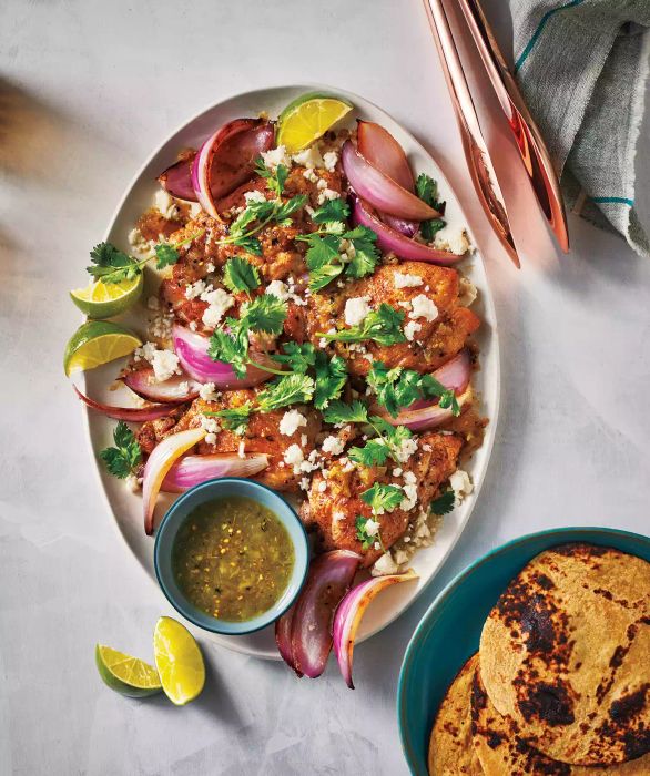 To achieve a golden-brown crust and a burst of flavor, sear the chicken thighs before baking them with salsa verde in this dish.