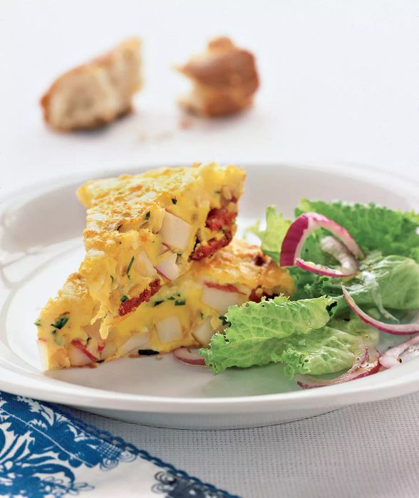 Spanish Omelet With Potatoes and Chorizo on a Plate Next to a Side Salad