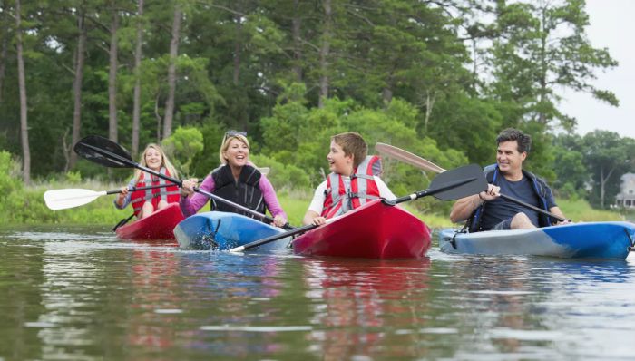A Caucasian family kayaking down a river