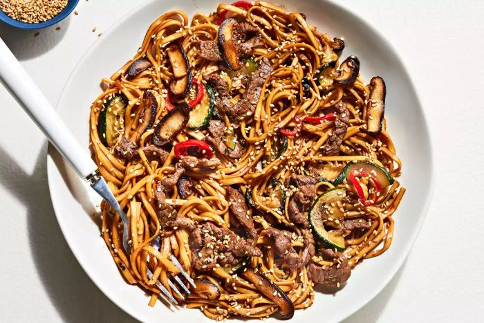 A delicious bowl of udon noodles, paired with seared beef, zucchini, and earthy mushrooms for a flavorful twist on the traditional Japanese dish.