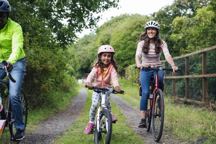 Family riding bikes through a public park