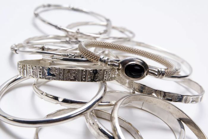 a collection of silver bangles stacked together