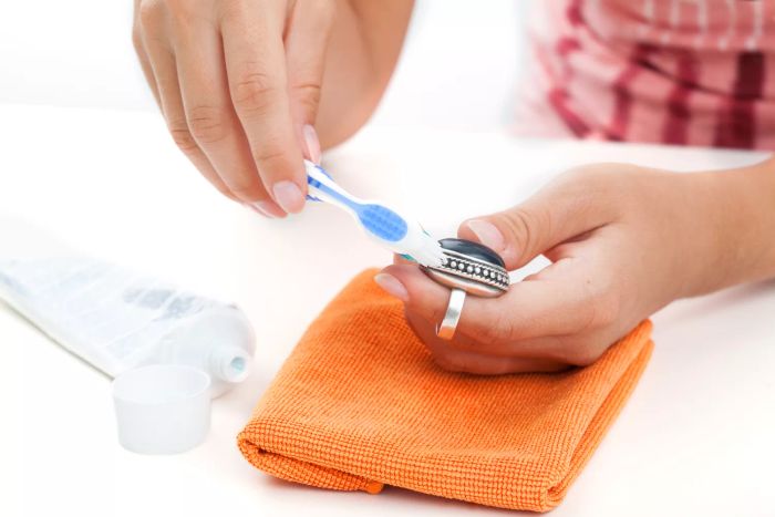 using a toothbrush to polish a silver ring
