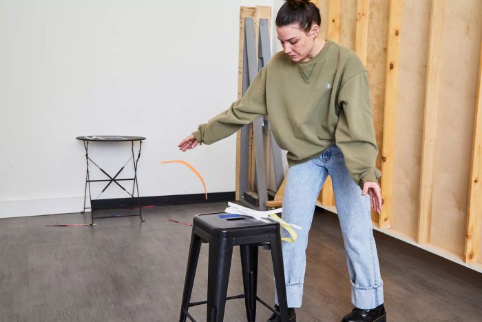 A tester catches pieces of paper as they are blown off a stool.