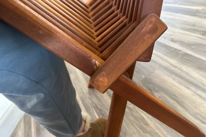 A person folding the Sand and Stable Abingdon Wood Folding Adirondack Chair.