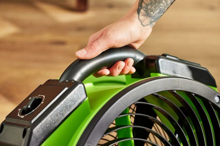 Tester grasping the handle of the XPOWER FC-200 Whole Room Air Mover