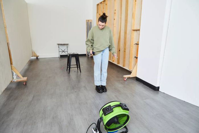 Tester feeling airflow from the XPOWER FC-200 Whole Room Air Mover