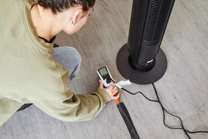 Person observing a meter to track the power consumption of the Dreo Nomad One Tower Fan