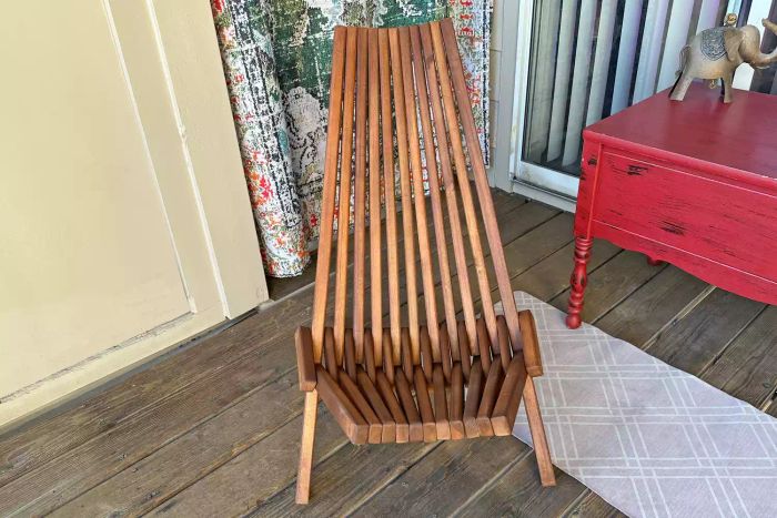 The Sand and Stable Abingdon Wood Folding Adirondack Chair placed in a sunroom.