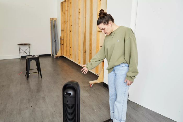 Person holding a hand in front of the Dreo Nomad One Tower Fan