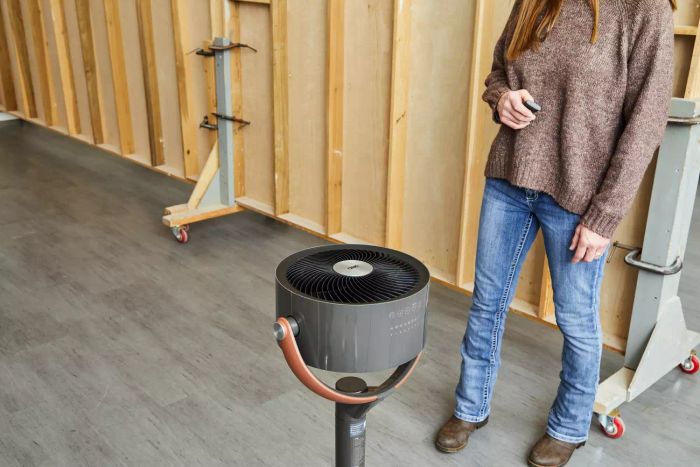 Tester adjusting the Dreo Pedestal Fan, directing airflow upwards