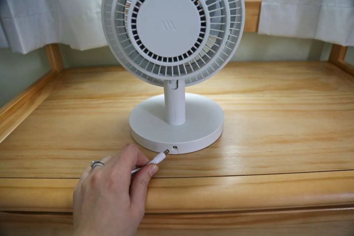 A person plugs the Windmill Air Circulator & Fan into a cable