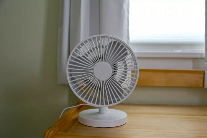 The Windmill Air Circulator & Fan plugged in on a wooden table