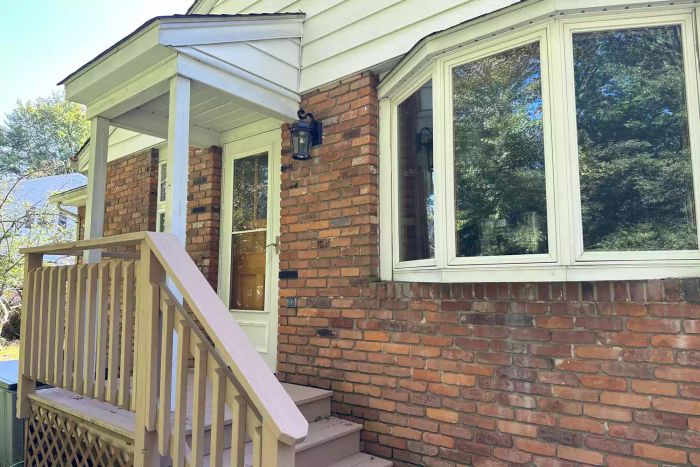 Euri Lighting EFL-130W-MD Flickering Flame Lantern affixed to the exterior of a house