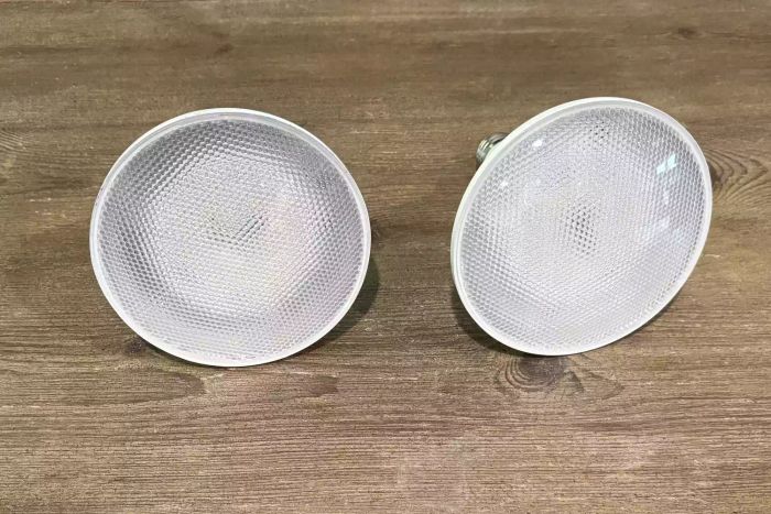 The GE CYNC Smart Outdoor Flood Light Bulbs placed on a wooden table surface