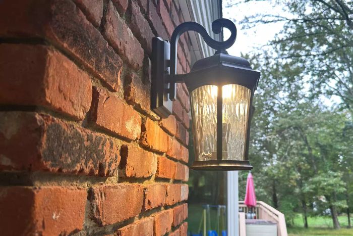 The Euri Lighting EFL-130W-MD Flickering Flame Lantern, installed and glowing on the exterior of a home