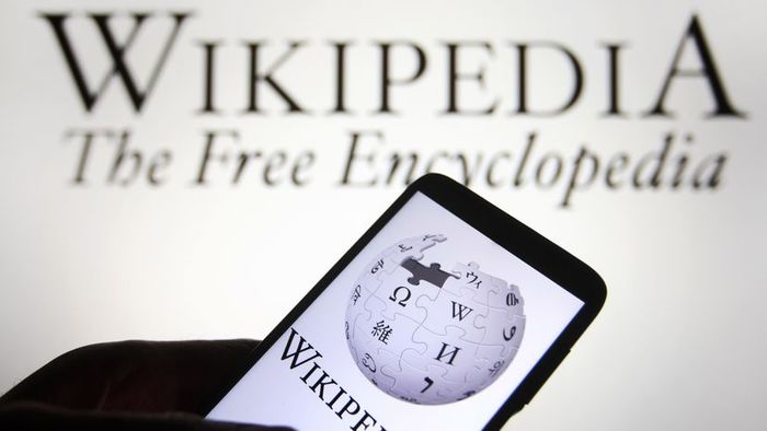 The Wikipedia logo appears on a smartphone screen
