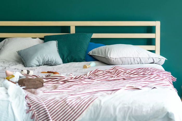 Baby's play area: parents' bed scattered with toys.