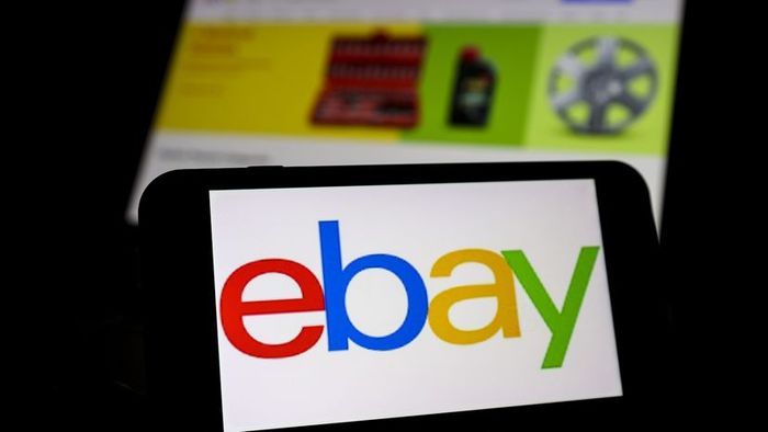 The eBay logo appears on a smartphone, with the website displayed on a screen in the background