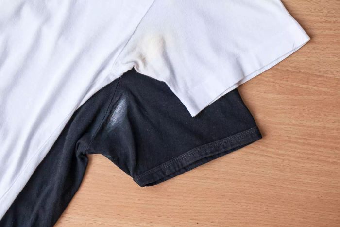 Shirts stained by roll-on deodorant against a wooden backdrop