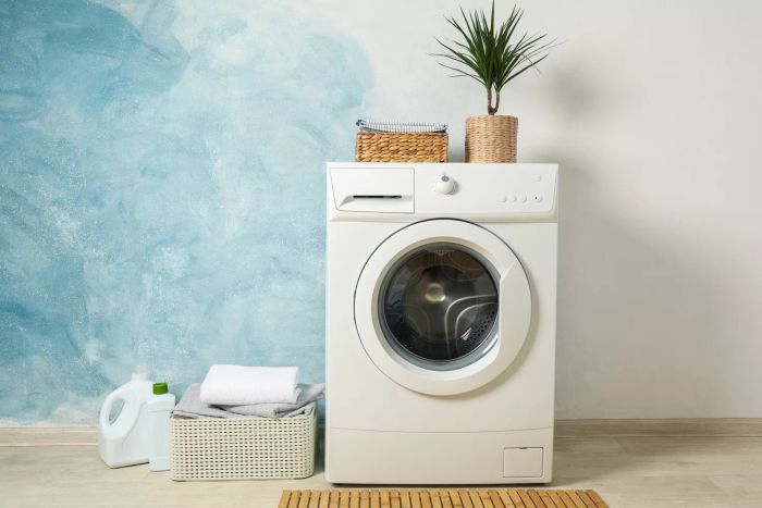 Laundry area featuring a washing machine on a light blue background, with room for text