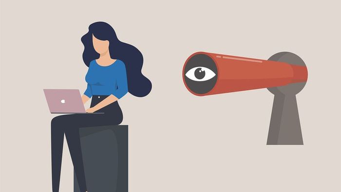 Illustration of a woman using a laptop with a large eye hovering over her