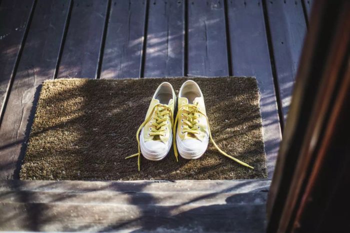 Image: Yellow sneakers on the doormat outside