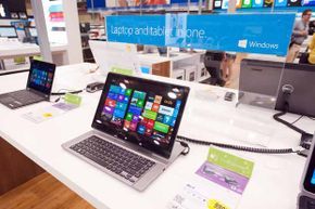 Brand new Microsoft laptops displayed in a retail environment.