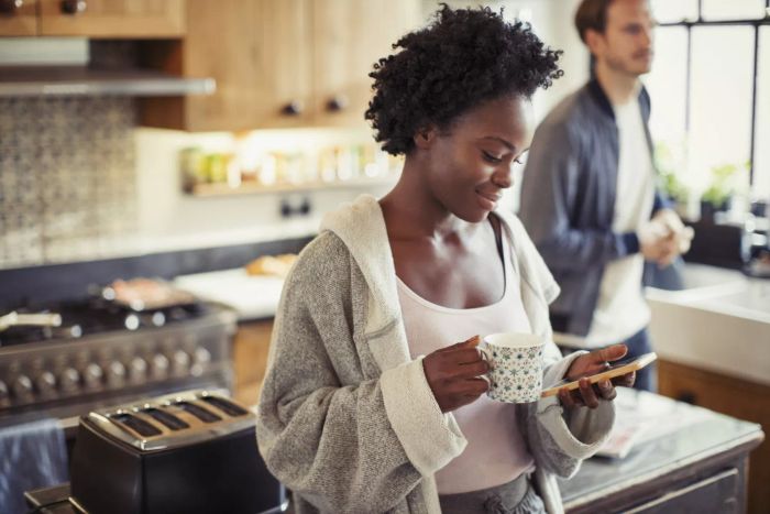 Image: Woman using her phone in the kitchen