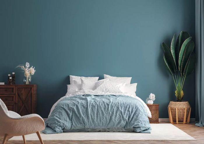 Interior design mock-up featuring a cozy, dark green bedroom with a potted palm plant