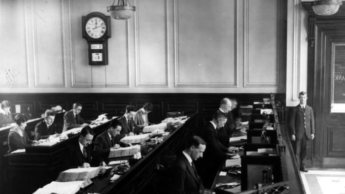 Bank clerks recording entries in ledgers in 1925.