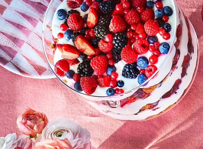 This berry trifle features whipped cream infused with elderflower, which complements the layers of fresh summer berries, while crushed cookies absorb the sweet berry juices.