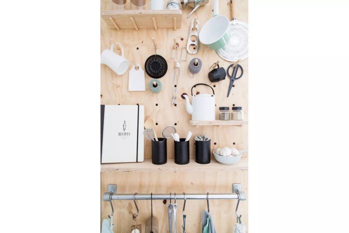 Wooden pegboard used for organizing kitchen items