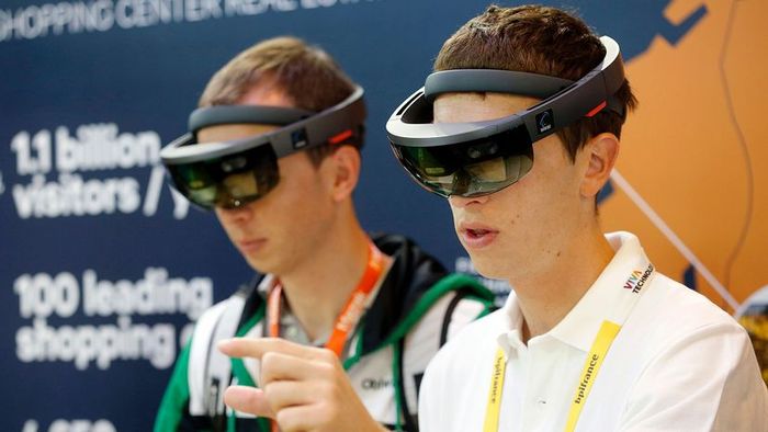 Two men are wearing AR glasses and interacting with the technology.