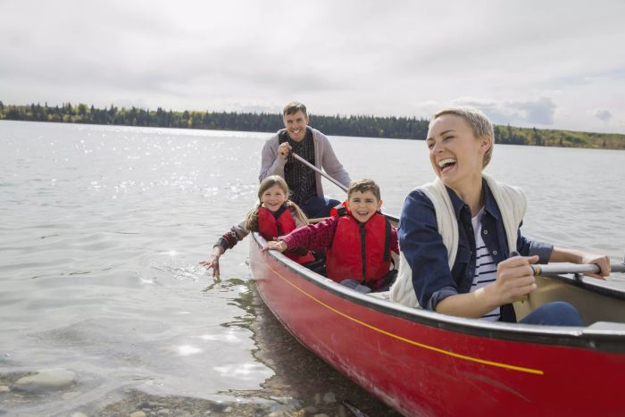 A joyful family paddling a canoe across a peaceful lake