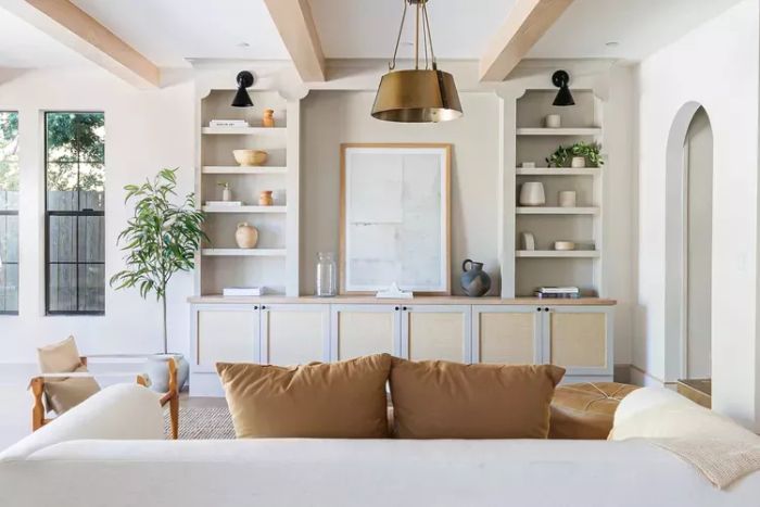 A spacious living room featuring white built-in bookshelves.