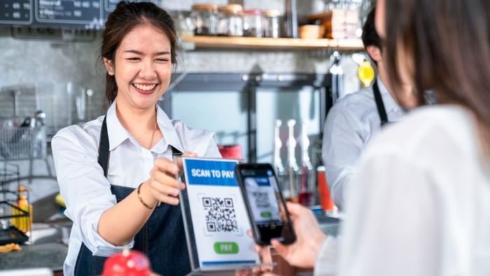 A business owner presenting a QR code to a customer for seamless payment.