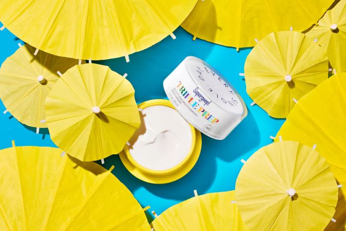 Supergoop's Triple Prep surrounded by bright yellow umbrellas