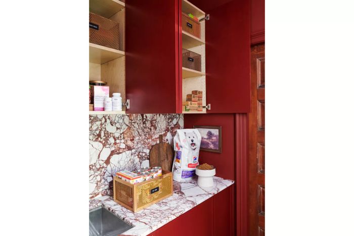 Striking red cabinets that beautifully contrast with the bold marble countertops