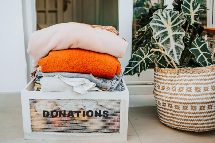 A donation box filled with clothes for charity placed at the entrance of a house