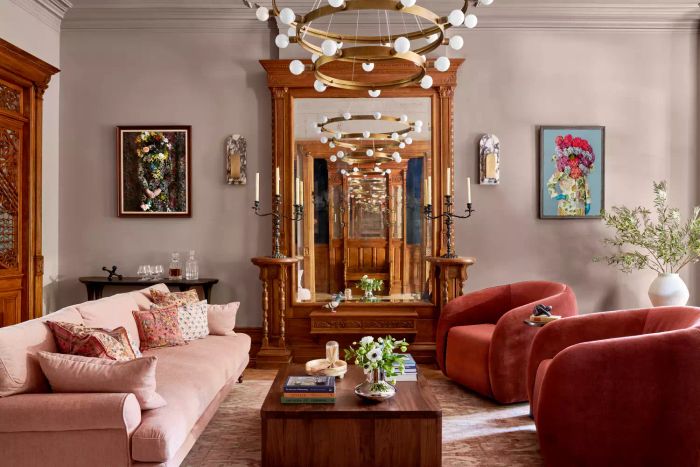 A living room featuring a pink sofa, wooden accents, and vibrant graphic designs