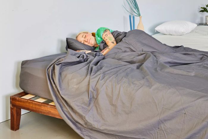 A person comfortably relaxing in the Sijo Home Organic Percale Cotton CrispCool Sheet Set